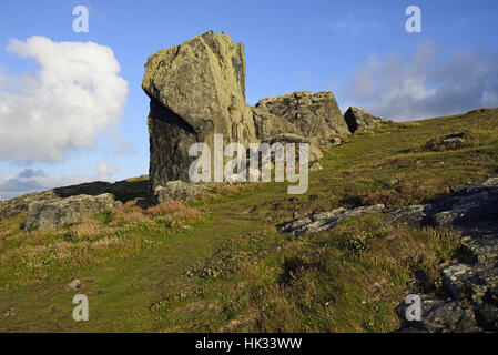 Gros rocher sur moor à Clodgy Point, Cornwall, près de St Ives, avec une masse nuageuse qui ressemble comme si elle est confrontée à la boulder. Banque D'Images