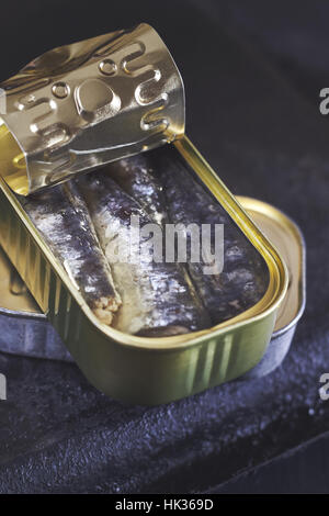 Les sardines en boîte sur fond rustique noir Banque D'Images