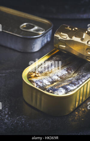 Les sardines en boîte sur fond rustique noir Banque D'Images
