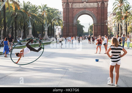 Barcelone, Espagne - 26 août 2014 : Acrobat avec hoop rend la performance dans le parc de la Ciutadella, l'Arc de Triomphe sur un arrière-plan Banque D'Images