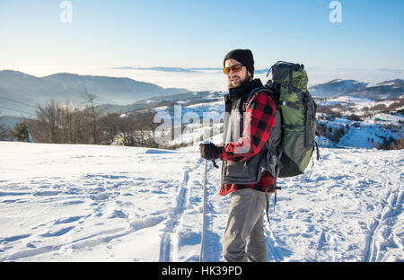 Homme randonnée sur le haut de la montagne enneigée Banque D'Images