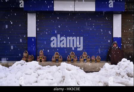 Srinagar, Inde. 25 Jan, 2017. Un homme cachemire vend Pot feu au milieu des flocons de neige dans certains Sopore à 55 kilomètres de Srinagar, la capitale d'été du Cachemire sous contrôle indien. Credit : Eeshan/pairs Pacific Press/Alamy Live News Banque D'Images