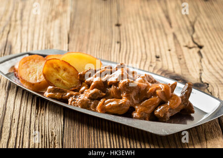 Bœuf Stroganoff, recette originale de plats russes. De fines lamelles de boeuf cuit dans la crème et la pâte de tomates, servi avec pommes de terre croquantes Banque D'Images