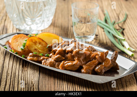 Bœuf Stroganoff, recette originale de plats russes. De fines lamelles de boeuf cuit dans la crème et la pâte de tomates, servi avec pommes de terre croquantes Banque D'Images