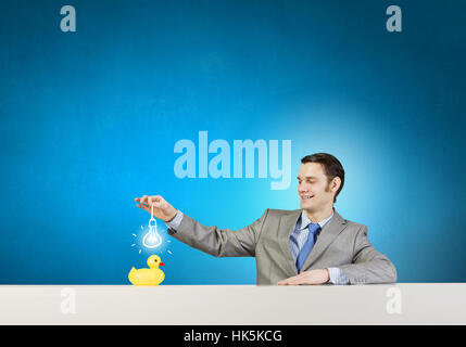 Funny businessman with yellow rubber duck toy Banque D'Images