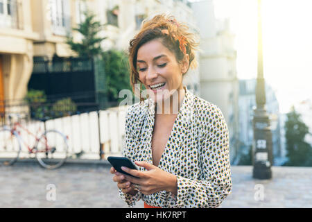 Paris, jolie femme visiter Montmartre et à l'aide d'un téléphone intelligent Banque D'Images