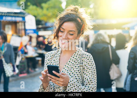 Paris, jolie femme visiter Montmartre et à l'aide d'un téléphone intelligent Banque D'Images