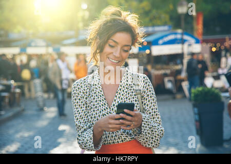 Paris, jolie femme visiter Montmartre et à l'aide d'un téléphone intelligent Banque D'Images