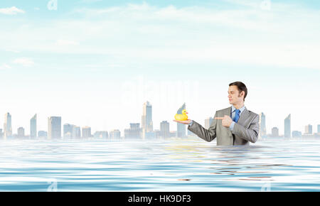 Funny businessman with yellow rubber duck toy Banque D'Images