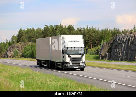 Camion de Big White transporte des marchandises le long de l'autoroute sur une belle journée d'été. Banque D'Images