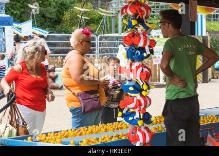 Un enfant gagnant le jeu duck pond en plastique au bon plaisir dans le parc Dreamland, Kent. Banque D'Images