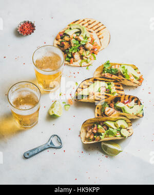 Tortillas de maïs sain avec filet de poulet grillé, avocat, de la salsa fraîche, des limes, de la bière dans des verres plus pâle en arrière-plan, selective focus. G Banque D'Images