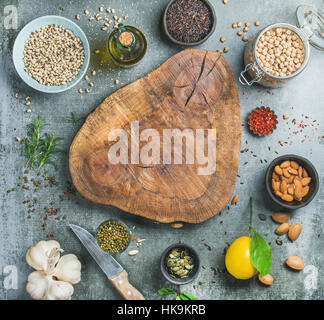 Ingrédients pour la cuisine santé. Variété de haricots, riz noir, pois chiches, amandes, graines, herbes, épices et huile d'olive sur le béton gris dos texturé Banque D'Images