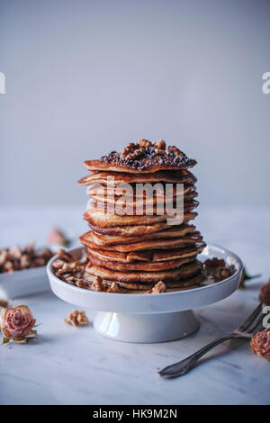 Pile de crêpes garnies de sirop d'érable, de noix et de cacao nibs Banque D'Images