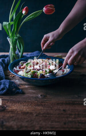 Femme en remuant de betterave, salade de fenouil et de pommes dans un grand bol de service Banque D'Images