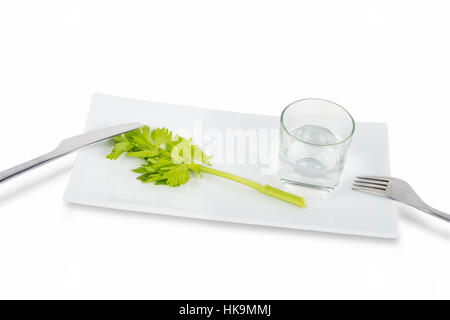 Tige de céleri et verre d'eau isolé sur fond blanc. Symbole de désordre et de l'alimentation l'anorexie. Banque D'Images