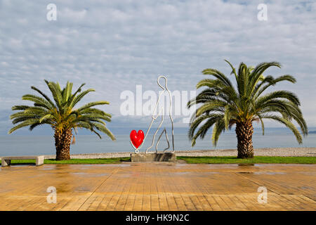Monument dédié à l'amour entre les palmiers sur la promenade le long de la mer Noire, à Batoumi, en Géorgie. Banque D'Images