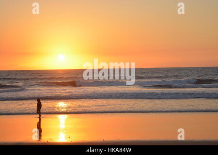 Balade à la plage sous un coucher de soleil Banque D'Images