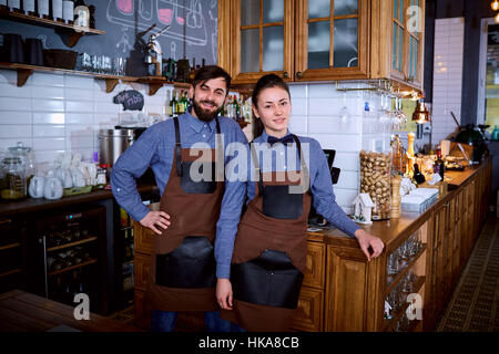 Deux travailleurs barista barman fille et un homme à l'oeuvre derrière la Banque D'Images