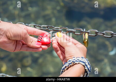 Femme main tenant un cadenas en forme de coeur Banque D'Images