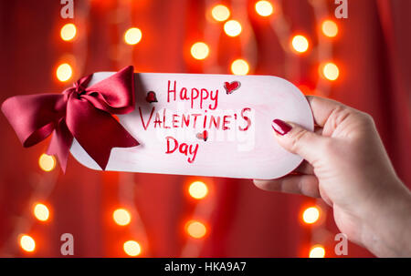 Femme hand holding Happy Valentines Day card Banque D'Images