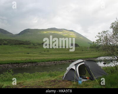 Camping sauvage avec tente dôme léger le long de la rivière près de Glencoe dans les Highlands, Ecosse, Royaume-Uni Banque D'Images