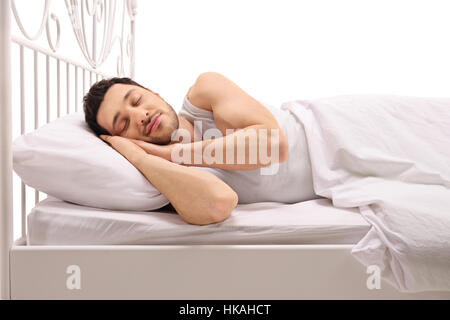 L'homme de dormir confortablement au lit isolé sur fond blanc Banque D'Images