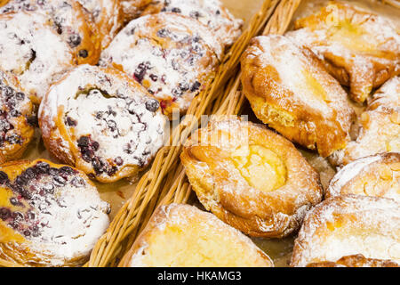 Brioches sucrées aux fruits rouges et le sucre en poudre sur les étagères de boulangerie Banque D'Images