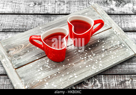 Tasses en forme de coeur rouge avec verre sur fond de bois rustique. Valentines Day concept Banque D'Images