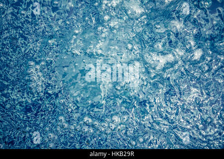 Fond de l'eau tourbillonnante dans les tons bleus avec des bulles et les ondes à la piscine Banque D'Images