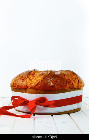 Panettone avec un arc rouge sur blanc Banque D'Images