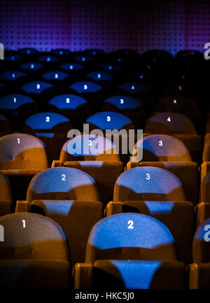 Sièges de cinéma Auditorium avec des numéros et des lumières bleues. Banque D'Images