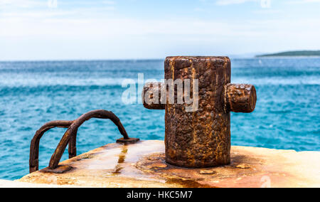 Old rusty amarrage acier pôle bollard sur un quai. La meilleure façon pour bateau ou navire amarre en port. La Croatie, Silba. Banque D'Images