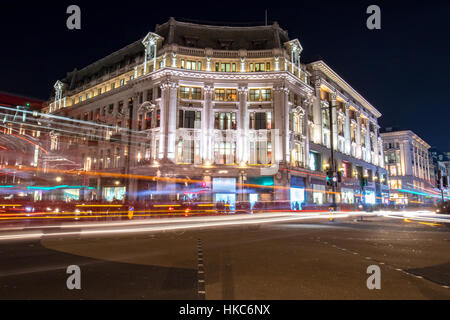 Vue de nuit sur un édifice au coin d'une des rues les plus animées de Londres Banque D'Images