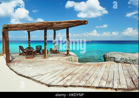 La terrasse en bois près de la plage avec de l'eau bleue Banque D'Images