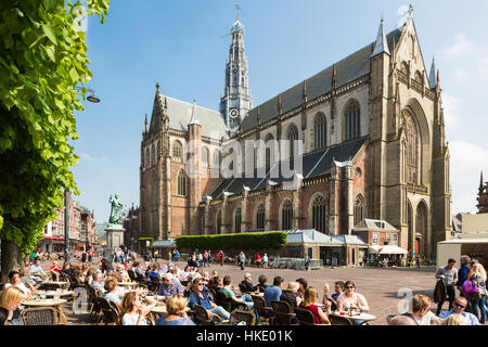 HAARLEM, Pays-Bas - le 27 mai 2016 : Les gens prendre un verre sur une terrasse de café sur la Grand-Place dans le centre de Haarlem avec vue sur la grande Banque D'Images