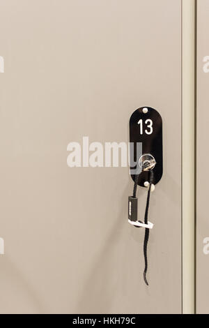 Armoires gris avec serrures et clés numérotées à l'école, de sport ou vestiaire. Banque D'Images