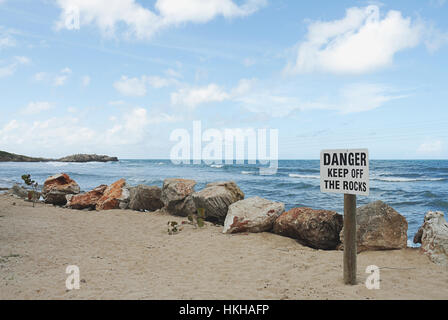 Inscrivez-vous sur plage avec Danger garder loin des rochers Banque D'Images