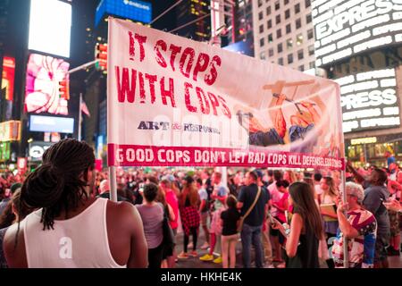 Au cours d'une vie noir Question manifestation à New York Times Square à la suite des coups de décès de Alton Sterling et Philando Castille, une jeune activiste afro-américain et un activiste du Caucase tenir un écriteau 'il s'arrête avec flics', 7 juillet 2016. Banque D'Images