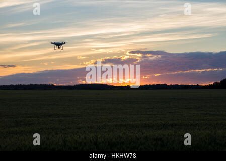 Drone silhouetté contre coucher du soleil orange Banque D'Images