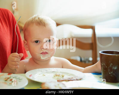 Petit garçon avec de l'alimentation à l'intérieur de la bouche sale house Banque D'Images