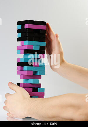 Mains tiennent tour Jenga couleur automne on white Banque D'Images