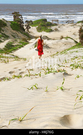 Femme en robe rouge, les dunes sur la côte, du delta du fleuve Tana, au Kenya Banque D'Images