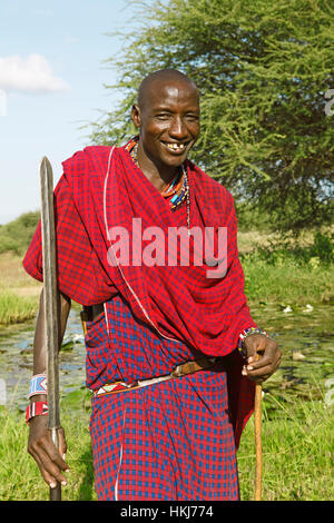 Masaï mâle en vêtements traditionnels Shuka avec lance, le parc national de Tsavo Ouest, comté de Taita-Taveta, Kenya Banque D'Images