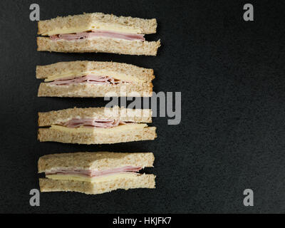 Sandwich au jambon et au fromage frais à la Farine Complète pain brun sur un fond noir, avec aucun peuple Banque D'Images