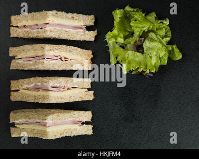 Sandwich au jambon et au fromage frais à la Farine Complète pain brun sur un fond noir, avec aucun peuple Banque D'Images