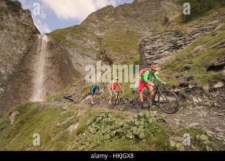 Mountain biker riding sur colline à cascade, Zillertal, Tyrol, Autriche Banque D'Images