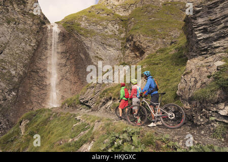 Trois amis motards regardant la montagne cascade, Zillertal, Tyrol, Autriche Banque D'Images