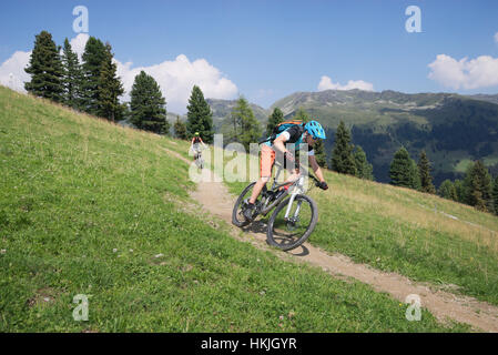Deux cyclistes de montagne équitation sur la descente dans un paysage alpin, Zillertal, Tyrol, Autriche Banque D'Images