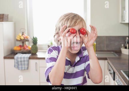 Garçon espiègle faisant face avec tomates, Bavière, Allemagne Banque D'Images